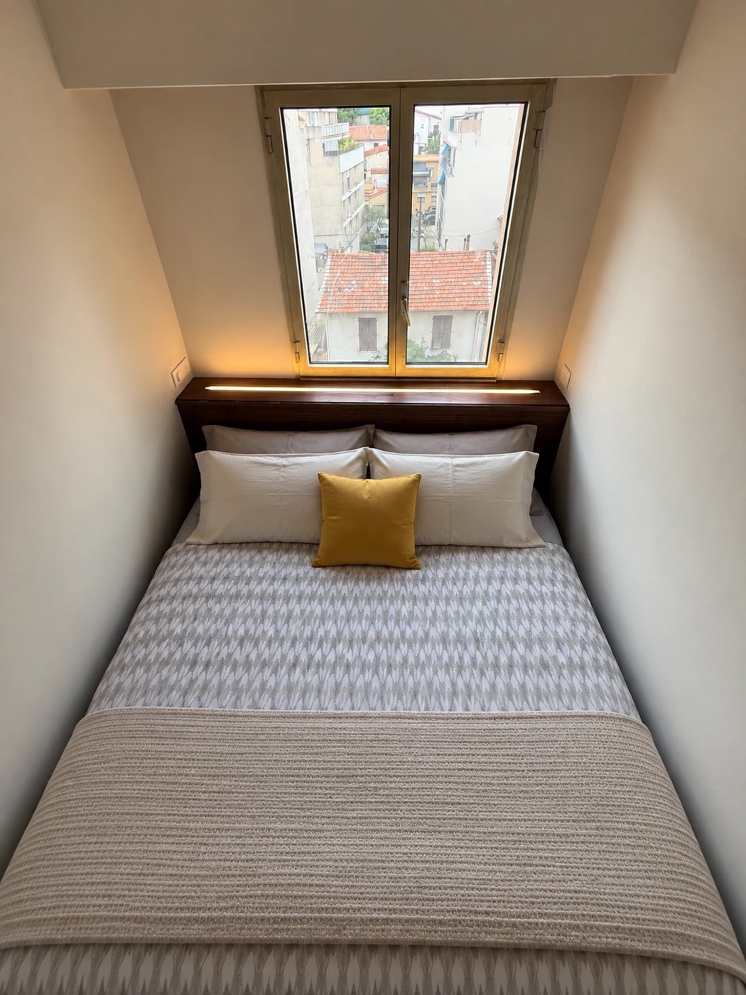 Chambre avec éclairage indirect par ruban LED encastré sous la tablette de fenêtre, au-dessus de la tête de lit